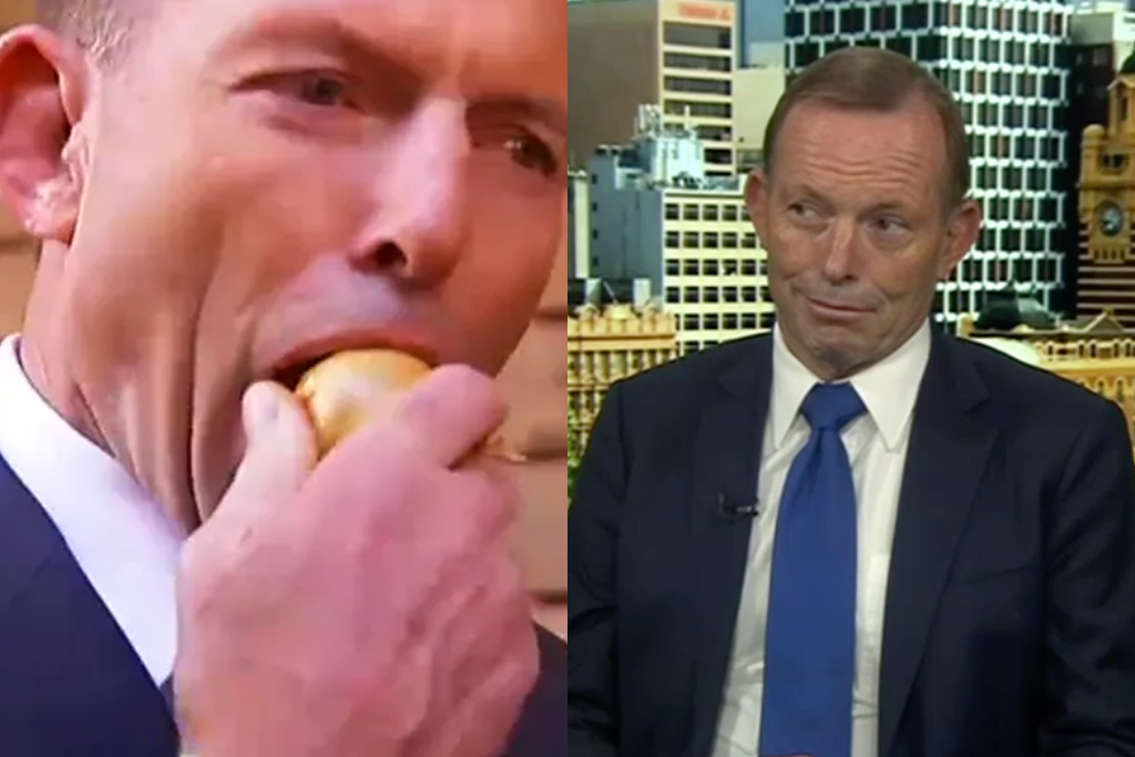 Tony Abbott eats a raw onion.