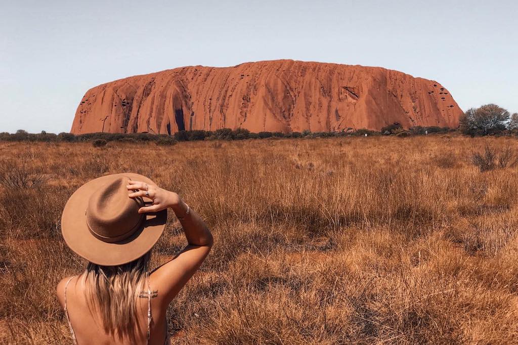 A woman standing in front of Uluru in the Northern Territory