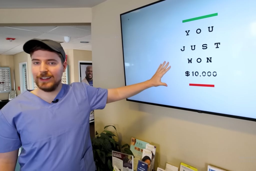 Youtuber Mr Beast standing next to a sign which reads "You Just Won $10,000"